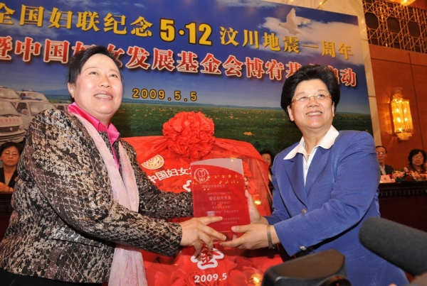 2009年5月5日，全国人大常委会副委员长、全国妇联主席陈至立（前右）向北京博宥投资管理集团有限公司董事长丁书苗颁发荣誉证书。当日，“全国妇联纪念512汶川地震一周年暨中国妇女发展基金会‘博宥基金’启动仪式”在北京人民大会堂举行。北京博宥集团公司捐赠1.5亿元人民币，设立中国妇女发展基金会“博宥基金”。博宥集团公司是一家综合性投资管理公司。董事长丁书苗曾在汶川地震发生后，以志愿者身份多次赶赴灾区，并向灾区捐款1000万元用于孤儿学校的建设。新华社记者何俊昌 摄