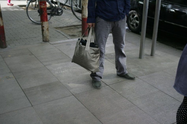 丁书苗的家人带了一包衣服守候在法庭门外。