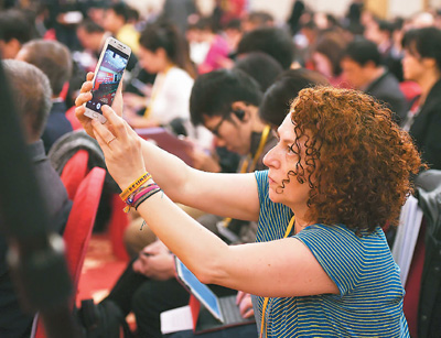 10月22日,在十九大新闻中心举办的记者招待会上,一位外国记者在抓拍精彩镜头。<p align=