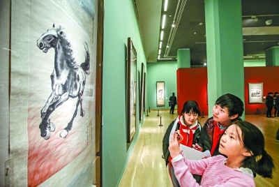 中国美术馆内，几名小学生在徐悲鸿画作《奔马》前观看临摹。实习记者 武亦彬摄 