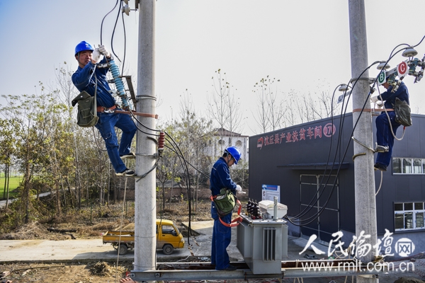 实施精准扶贫、坚决打赢脱贫攻坚战以来，河南省沈丘县在各乡镇陆续建成一批扶贫车间。该县供电部门针对不同项目，合理布局供电方式，目前，已配套建设了160台专用变压器，容量69000千伏安，可靠保障了扶贫生产需要，吸引不少农民返乡创业，为贫困户提供了11000多个就业岗位，实现了脱贫致富梦。图为施工人员为卞路口乡扶贫车间安装供电设施。（摄影：赵腾明）