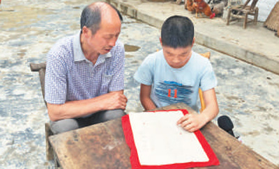李道海（左）和儿子在看红军宣传单。
杨洪霞摄（人民视觉） 