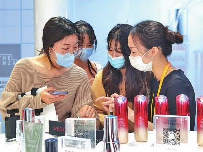 进博会美妆护肤品展台的工作人员邀请观众体验展品。本报记者 吴潇怡摄:光明图片