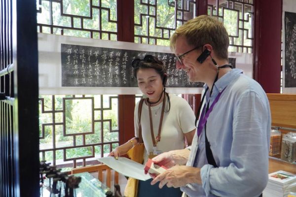 2024“一带一路”媒体合作论坛联合采访调研行成员在三苏祠挑选文创产品。人民网记者 赵祖乐摄