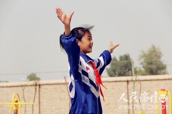 四十九团小学生在指挥"童心向党"合唱(何志江 摄)