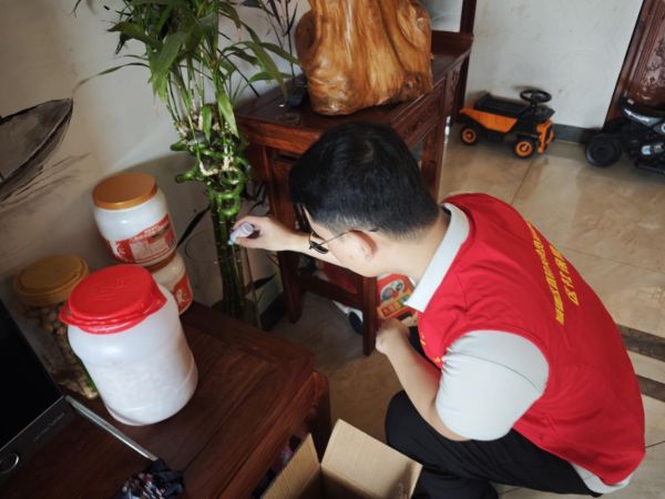區(qū)社保局工作人員入戶為已換水的植物添加防蟲藥劑