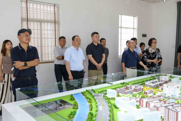 人民论坛调研组观看浙江万里学院余姚校区规划沙盘及宣传片。