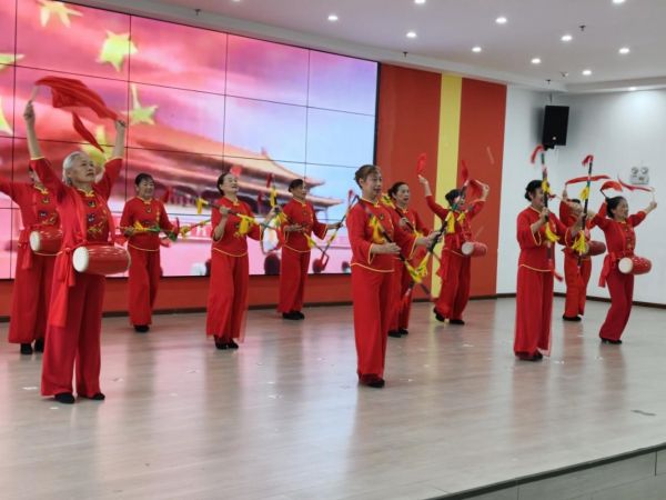 演员们跳着金钱棍腰鼓舞《中国红》。
