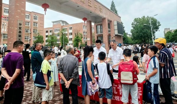 分宜烟草普法人员在学校门口开展电子烟危害教育宣传。