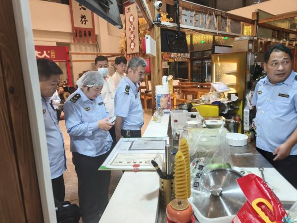 执法人员对商家营业执照及索证索票进行查验。