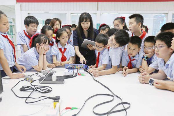 在“5.20”世界计量日,计量工作人员向五里店小学小朋友科普计量知识