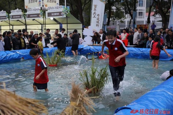 游客在旅发大会会场体验稻田捉鱼趣味。怀化日报全媒体记者 彭军 摄影